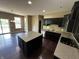 Modern kitchen featuring black cabinets, hardwood floors, granite countertops, and an island at 14462 Brook Meadow Dr, McCordsville, IN 46055