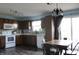 Well-lit kitchen and dining area with dark wood cabinetry, stainless steel appliances, and modern light fixtures at 1461 Ripplewood Dr, Danville, IN 46122