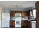 Bright kitchen with wooden cabinets, a mosaic backsplash, and white appliances, creating a functional space at 1461 Ripplewood Dr, Danville, IN 46122