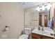 Well-lit half bathroom with a white toilet, sink, vanity, and a decorative mirror at 14814 Beacon Blvd, Carmel, IN 46032