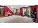 Inviting living room featuring a red accent wall, neutral carpet, console table, and a bench by the window at 14814 Beacon Blvd, Carmel, IN 46032