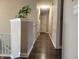 Hallway with hardwood floors and neutral paint provides access to various rooms in the home at 1714 Michelle Mnr, Danville, IN 46122