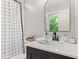 This bathroom has a black faucet, dark cabinets, a white counter, and a shower-tub combo at 1829 Kessler Blvd W Dr, Indianapolis, IN 46228