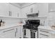 Kitchen with white cabinets, black hardware, subway tile backsplash, and stainless steel appliances at 1829 Kessler Blvd W Dr, Indianapolis, IN 46228