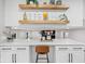 Modern kitchen with white cabinets, floating wood shelves, and quartz countertops at 1829 Kessler Blvd W Dr, Indianapolis, IN 46228