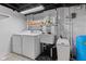 Functional laundry area with white washer, dryer, utility sink, and a blue water softener at 1829 Kessler Blvd W Dr, Indianapolis, IN 46228