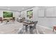 Open floor plan with dining area and living room, large windows, and light wood flooring at 1829 Kessler Blvd W Dr, Indianapolis, IN 46228