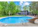 Relax by the refreshing pool, complete with slide, surrounded by lush greenery for ultimate privacy at 1829 Kessler Blvd W Dr, Indianapolis, IN 46228