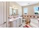 Bright bathroom featuring a double sink vanity, a separate tub, and checkered tile flooring at 186 W 600 N, Alexandria, IN 46001
