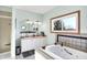 Bright bathroom featuring double sinks, a tiled shower, and a soaking tub by a window at 186 W 600 N, Alexandria, IN 46001