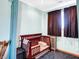 A bedroom featuring a wooden crib, brown curtains, and light blue walls at 186 W 600 N, Alexandria, IN 46001