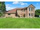Charming two-story brick home with lush green lawn and well-maintained landscaping at 186 W 600 N, Alexandria, IN 46001