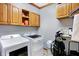 Laundry room featuring modern washer and dryer units, storage cabinets, and organized space at 186 W 600 N, Alexandria, IN 46001