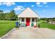 A small shed on a concrete pad is enhanced by the red door and bench seating at 186 W 600 N, Alexandria, IN 46001