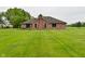 Expansive green backyard featuring a brick home with a chimney and sliding glass doors at 2090 W County Road 400 S, Clayton, IN 46118