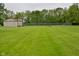 Fenced backyard featuring a large lawn, outbuildings, and mature trees at 2090 W County Road 400 S, Clayton, IN 46118