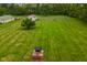 Aerial view of the backyard with outbuildings, a well-kept lawn, and privacy trees at 2090 W County Road 400 S, Clayton, IN 46118