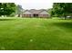 Charming brick home featuring a spacious front yard with mature trees on a partially cloudy day at 2090 W County Road 400 S, Clayton, IN 46118