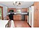 Traditional kitchen boasts wood cabinets, hardwood floors, and black appliances at 2090 W County Road 400 S, Clayton, IN 46118