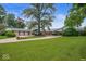 Charming ranch home with a large front lawn, mature trees, and an American flag flying high at 3000 E County Road 400 N, Muncie, IN 47303