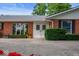 Charming home exterior with a well-manicured lawn, brick facade, and a welcoming double-door entrance at 3000 E County Road 400 N, Muncie, IN 47303