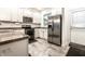 Well-lit kitchen features stainless steel appliances, white cabinets, and stylish gray tile flooring at 3047 N New Jersey St, Indianapolis, IN 46205