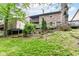 Backyard view of a brick home with a two-level deck, mature trees, and grassy hillside at 3348 Fox Orchard Cir, Indianapolis, IN 46214