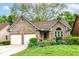 Charming brick home featuring a two-car garage, well-manicured lawn, and colorful flower beds at 3348 Fox Orchard Cir, Indianapolis, IN 46214