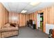 Finished basement living room area features wood paneling, comfy sofa, and entrance to an office space at 3348 Fox Orchard Cir, Indianapolis, IN 46214