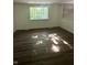 Sunny bedroom featuring a large window, white walls, and hardwood floors at 3541 Alpine Pl, Indianapolis, IN 46226