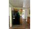 Spacious kitchen includes a black refrigerator with water dispenser, wood cabinets and newly installed vinyl floors at 3541 Alpine Pl, Indianapolis, IN 46226
