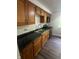 Well-lit kitchen features stainless steel appliances, wood cabinets with dark countertops, new faucet, and vinyl flooring at 3541 Alpine Pl, Indianapolis, IN 46226