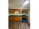Modern kitchen features stainless steel appliances, dark countertops, wood cabinets, and new vinyl floors at 3541 Alpine Pl, Indianapolis, IN 46226