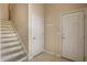 Inviting entryway with tiled floor, staircase, and convenient coat hooks near the front door at 3556 Towne Dr, Carmel, IN 46032
