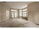Open living room with carpet flooring, bright windows, and doors leading to the outside at 3556 Towne Dr, Carmel, IN 46032