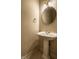 Simple powder room featuring a pedestal sink, a round mirror, and neutral wall color at 3556 Towne Dr, Carmel, IN 46032