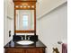 Bathroom with a dark granite vanity, wood frame mirror, and white beadboard paneling at 3918 N Park Ave, Indianapolis, IN 46205