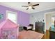 This colorful bedroom includes hardwood floors, a ceiling fan, and a whimsical pink tent at 3918 N Park Ave, Indianapolis, IN 46205