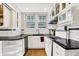 Well-lit kitchen with black countertops, white cabinets, and stainless steel appliances at 3918 N Park Ave, Indianapolis, IN 46205
