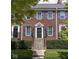 Charming brick townhome with classic blue shutters and meticulously maintained landscaping at 4024 Heyward Pl, Indianapolis, IN 46250