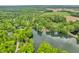 Expansive aerial perspective of a lake surrounded by a forest and some farmland at 4154 W Briarwood Lake S Dr, Monrovia, IN 46157
