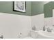 Neat half bathroom with a toilet and sink with white subway tiles at 4159 Persian St, Greenwood, IN 46143