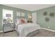 Cozy bedroom featuring soft green walls, a plush bed, ample natural light, and stylish decorative accents at 4159 Persian St, Greenwood, IN 46143