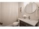 Small bathroom with toilet, sink, marble countertops and round mirror at 4190 Hartswick Ct, Zionsville, IN 46077