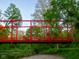 Vibrant red bridge crossing a waterway, surrounded by lush greenery at 4190 Hartswick Ct, Zionsville, IN 46077