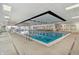 Bright indoor pool area with lap lanes, chairs, hot tub and lifeguard station at 4190 Hartswick Ct, Zionsville, IN 46077