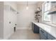 Neat laundry room with modern sink, quartz countertops and blue cabinets at 4190 Hartswick Ct, Zionsville, IN 46077