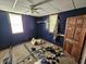Blue bedroom with paneled walls, two windows, and carpeted floor at 421 N Canal St, Alexandria, IN 46001