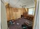 Unique attic bedroom featuring angled ceilings, wood paneled walls, and a classic ceiling fan at 421 N Canal St, Alexandria, IN 46001