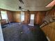 Cozy living room featuring wood paneled walls, carpeted floors, and a classic ceiling fan at 421 N Canal St, Alexandria, IN 46001